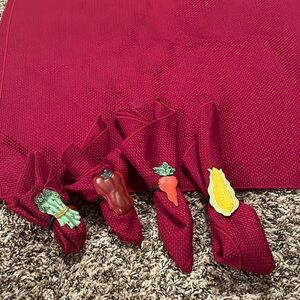 Burgundy cloth table cloth and four cloth napkins and vegetable napkin rings